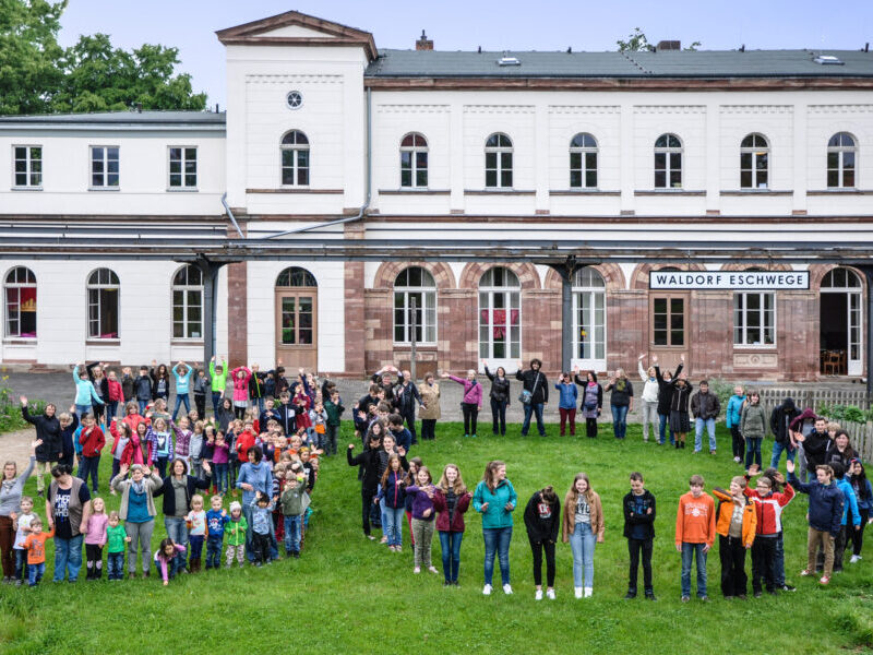 Schüler stehen in Form einer 30 vor dem Schulgebäude der Freien Waldorfschule Werra-Meißner